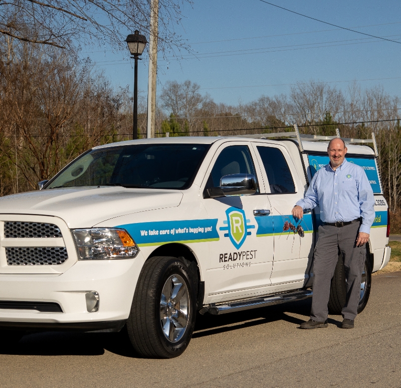 quote image Ready Pest Solutions owner standing next to truck